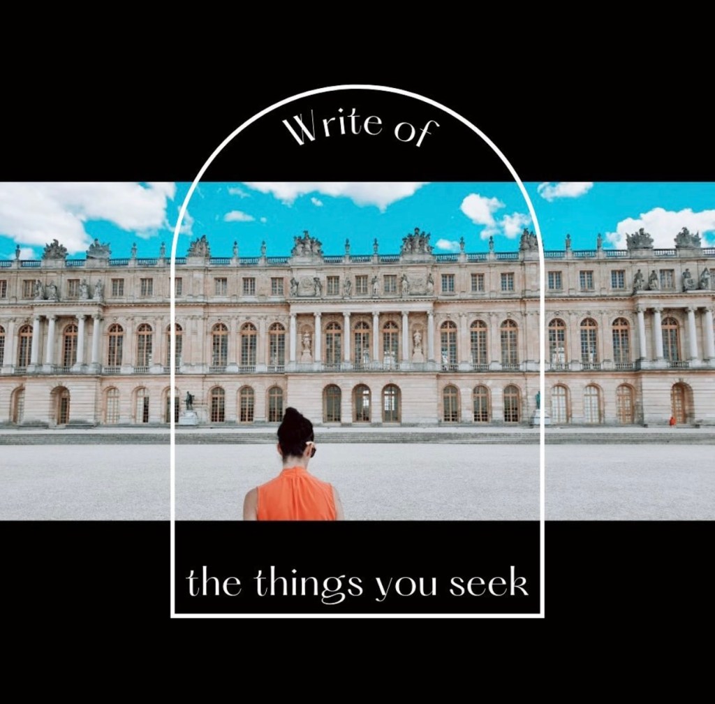 Woman with dark hair in bun wearing an orange shirt standing facing the back of the Palace of Versailles with the blue sky showing in the top with text saying write the things you seek 